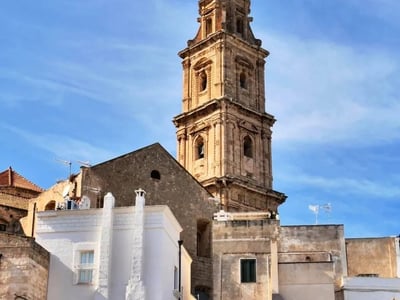 Cathédrale Maria Santissima della Madia, avec son imposant clocher, se dresse majestueusement sous un ciel bleu pur.