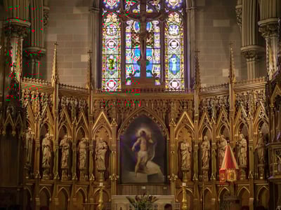 Majestic choir of St. Patrick's Cathedral, with colorful stained glass and detailed sculptures of the apostles.