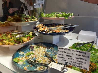 Colorful salads and empty dishes at the Ottolenghi restaurant in Notting Hill, showcasing fresh and flavorful ingredients.