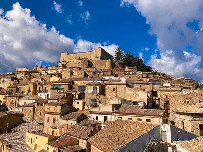 Vue pittoresque de Sant'Agata di Puglia, montrant ses maisons colorées avec en arrière-plan le château historique.
