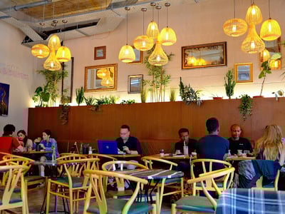 Ambiance chaleureuse et accueillante au Music & Beans, avec des clients savourant café et moments de créativité.