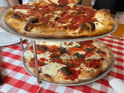 Two delicious thin-crust pizzas topped with tomato sauce and mozzarella, served at Grimaldi's Pizzeria.