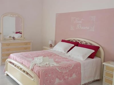 Comfortable room at Da Zia Betty Casa Vacanza, with a double bed and soft pink decor.