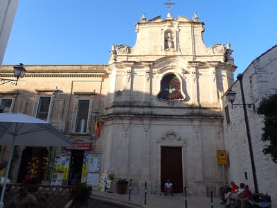 Église de San Cataldo, avec sa façade baroque, située à l'intérieur d'un charmant village méditerranéen.