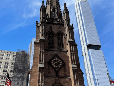 Église Trinity à New York, présentant son architecture gothique distincte contrastant avec des gratte-ciels modernes.