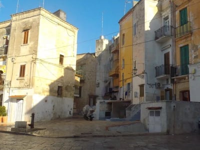 Ruelle tranquille à Bari, avec des bâtiments colorés et pavés, illustrant le charme pittoresque de la vieille ville.