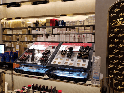 Le comptoir de maquillage Shiseido chez Zitomer Pharmacy, mettant en avant une sélection de rouges à lèvres et fond de teint.