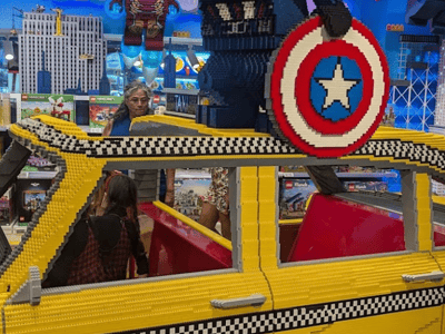 Yellow LEGO® taxi with a character holding a shield, located at the LEGO® Store Fifth Avenue in New York.