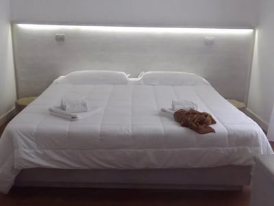 Elegant room with a comfortable double bed and modern lighting at the Sui Tetti Luxury Rooms Hotel.