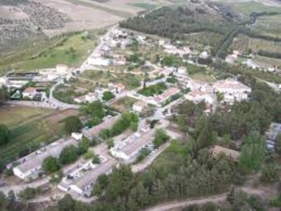 Panoramic view of the Pantano de los Bermejales, showing the houses, greenery, and surrounding landscape.
