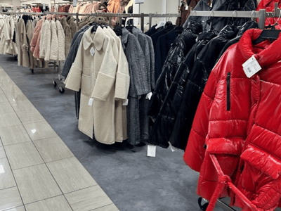 Winter clothing on sale at Century 21 in NYC, including plush coats, leather, and bright colors.