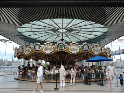 Jane's Carousel, a colorful carousel with sculpted horses, located in Brooklyn Bridge Park, attracting families and children.