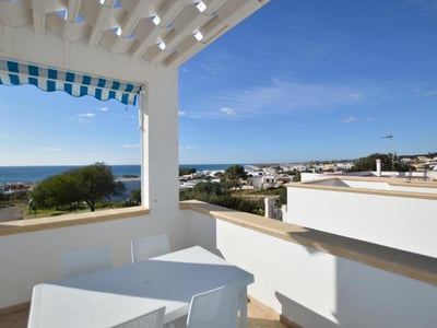 Panoramic view from the balcony of the Mare Blu Apartments, with the sea in the background and a clear sky.