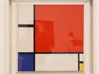 Abstract composition by Piet Mondrian, exhibited at Tate Modern, combining red, black, yellow, and blue.