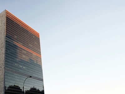 Reflet du ciel sur la façade moderne du Siège de l'ONU à New York, symbolisant l'engagement international.
