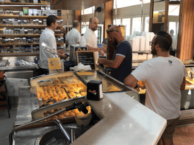 Clients interact at the Bar Kennedy counter, tasting local specialties in a friendly atmosphere.