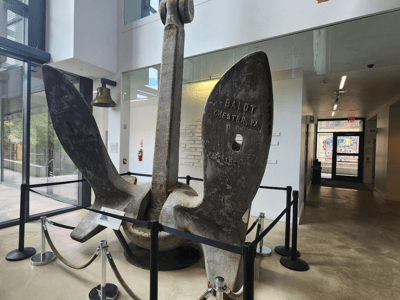 Massive metal anchor displayed inside Building 92, symbolizing local maritime history and innovation.