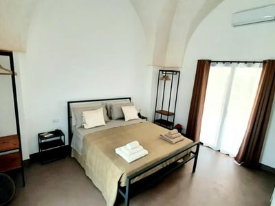 Chambre moderne et lumineuse à la Casina Pompiliano, avec un lit double et une vue sur la nature environnante.