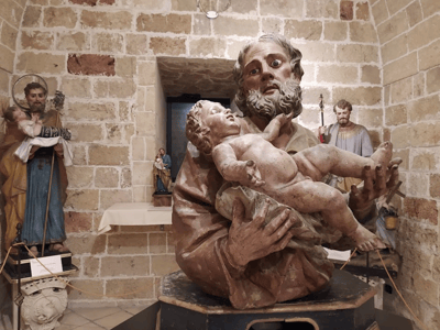Statue of Saint Joseph holding the Child Jesus, displayed at the Diocesan Museum, highlighting regional sacred art.