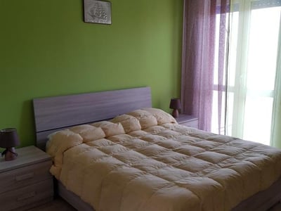 Chambre confortablement décorée avec un lit double douillet et des murs verts au La Casa di Nico.
