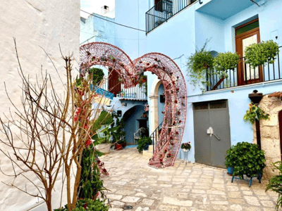 Un cœur décoratif en fleurs dans une ruelle pittoresque de Casamassima, reflétant le charme méditerranéen du village.