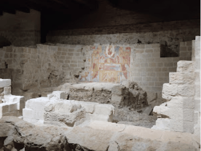 Vestiges du château d'Acaya, révélant des murs en pierre et une fresque médiévale, témoignant de son histoire riche.
