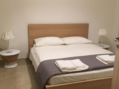 Comfortable and modern room at the Collins Apartments, with a double bed and minimalist decor. Perfect for relaxing.