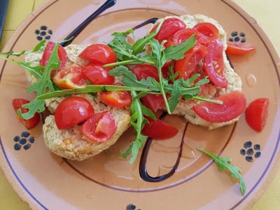 Bruschetta garnie de tomates fraîches et roquette, servie à Rendez-Vous, idéale pour un repas léger et savoureux.