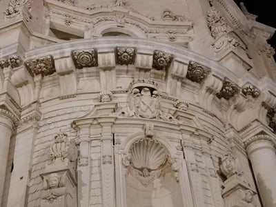 Détails architecturaux ornés de la façade d'une église à Lecce, mettant en valeur la richesse du baroque italien.