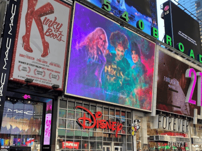 Façade du Disney Store à Times Square, avec des affiches colorées et une publicité pour des films emblématiques.