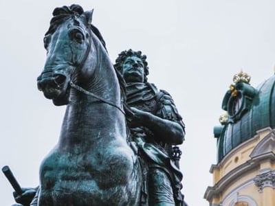 Equestrian statue of a king in front of the sumptuous Charlottenburg Palace, a symbol of baroque architecture in Berlin.