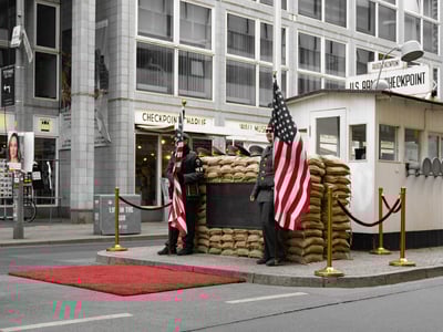 Historical bunker of Checkpoint Charlie, with soldiers and American flags, a symbol of the Cold War in Berlin.