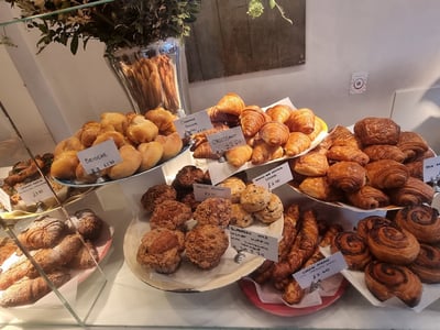 Delicious assorted pastries at the Ottolenghi Notting Hill counter, including croissants, muffins, and fresh brioche.