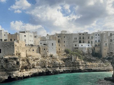 Falaises et maisons blanches surplombant la mer turquoise à Polignano a Mare, célèbre pour ses paysages pittoresques.