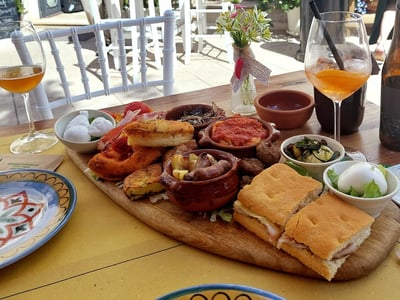 Colorful plate of assorted tapas at Tò - Aperitifs and the like, with refreshing drinks on the terrace.