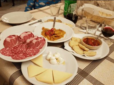 Assiette de charcuterie et antipasti à l'Osteria Pugliese, mettant en avant des saveurs italiennes authentiques.