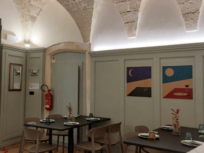 Intérieur de Pizzeria Storico avec des tables élégantes, des murs colorés, et un éclairage accueillant, parfait pour un repas décontracté.