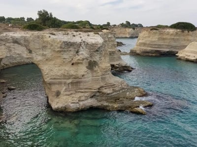 Rocky coast of Torre Sant'Andrea with limestone formations sculpted by the sea and crystalline turquoise waters.