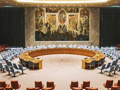 UN Security Council chamber, featuring comfortable seats and a large impressive mural.