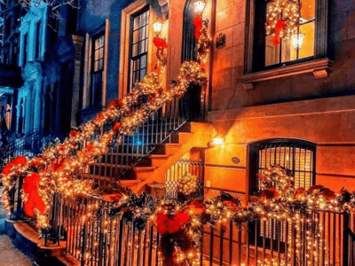 Festive stairway decorated with string lights and Christmas wreaths on the Upper East Side, creating a bright and welcoming atmosphere.