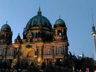 Vue du Berliner Dom illuminé à la tombée de la nuit, mettant en valeur son architecture baroque majestueuse.