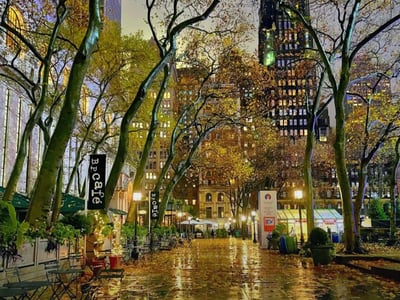 Union Square lit by streetlights, with autumn leaves on the ground and buildings in the background.