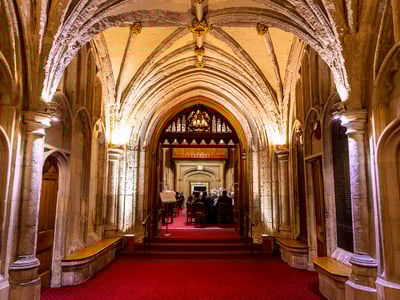 Couloir du Guildhall, mettant en valeur l'architecture médiévale et les invités réunis autour d'une table.