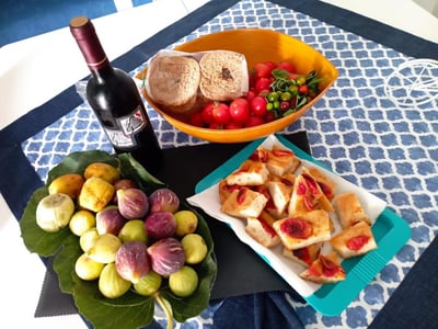 Assiette de fruits frais, pain et vin, typique de la cuisine locale, à Da Zia Betty Casa Vacanza.