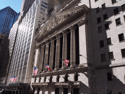 Bâtiment emblématique de la Bourse de New York avec drapeaux américains, situé dans le quartier financier de Manhattan.