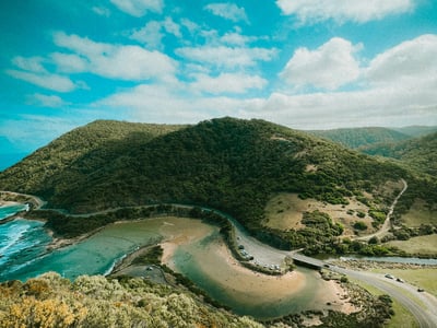 Vue panoramique de Kennett River, montrant la côte, des collines verdoyantes et une route serpentant le long du rivage.