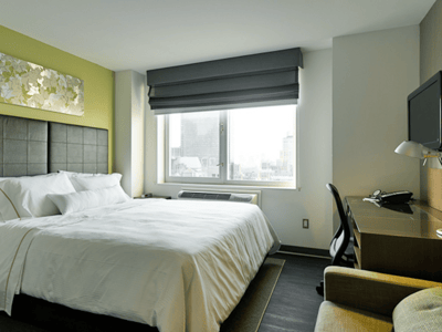 Chambre moderne au Element New York Times Square West, avec lit king-size, vue sur la ville et décor apaisant.