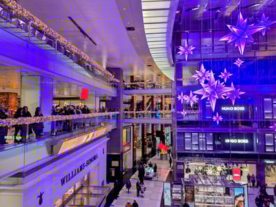 Vue intérieure du Times Warner Center, avec décorations lumineuses, boutiques et nombreux visiteurs profitant des fêtes.