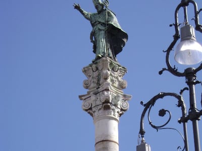 Colonne de Sant’Oronzo, statue emblématique surmontant une colonne, symbole de la ville de Lecce. Ciel bleu éclatant.
