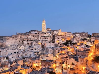 Vue nocturne envoûtante de la ville historique de Matera avec ses maisons troglodytes illuminées.